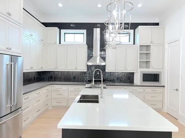 a kitchen with kitchen island granite countertop a sink cabinets and stainless steel appliances