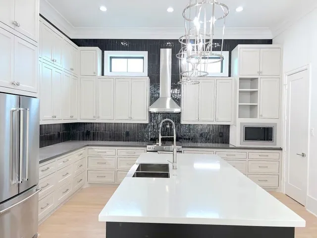 a kitchen with kitchen island granite countertop a sink cabinets and stainless steel appliances
