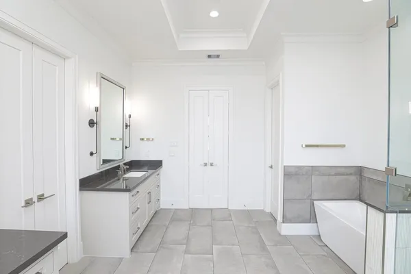 a spacious bathroom with a granite countertop sink and a mirror