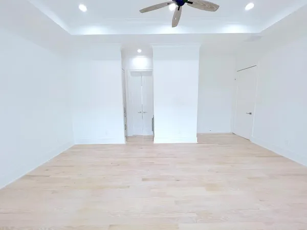 a view of an empty room with a window and a ceiling fan