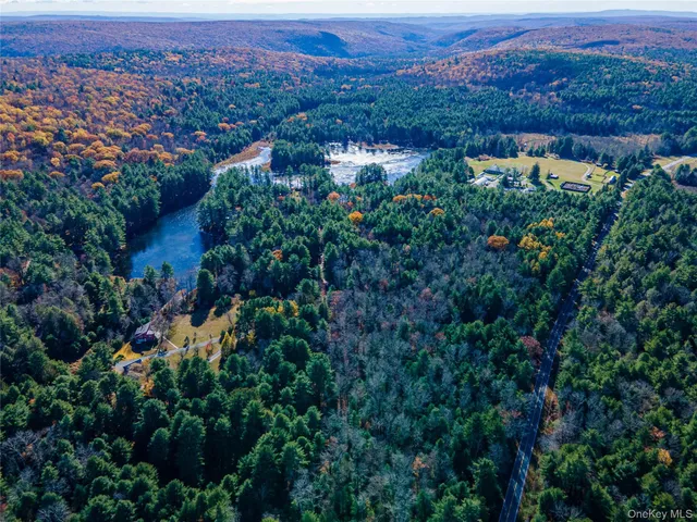 an aerial view of residential house with outdoor space and trees all around