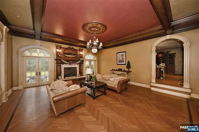 a living room with furniture a chandelier and a flat screen tv