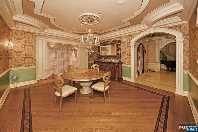 a dining room with furniture a chandelier and wooden floor