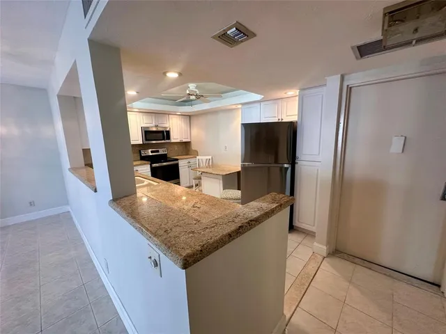 a kitchen with stainless steel appliances granite countertop a refrigerator and a sink