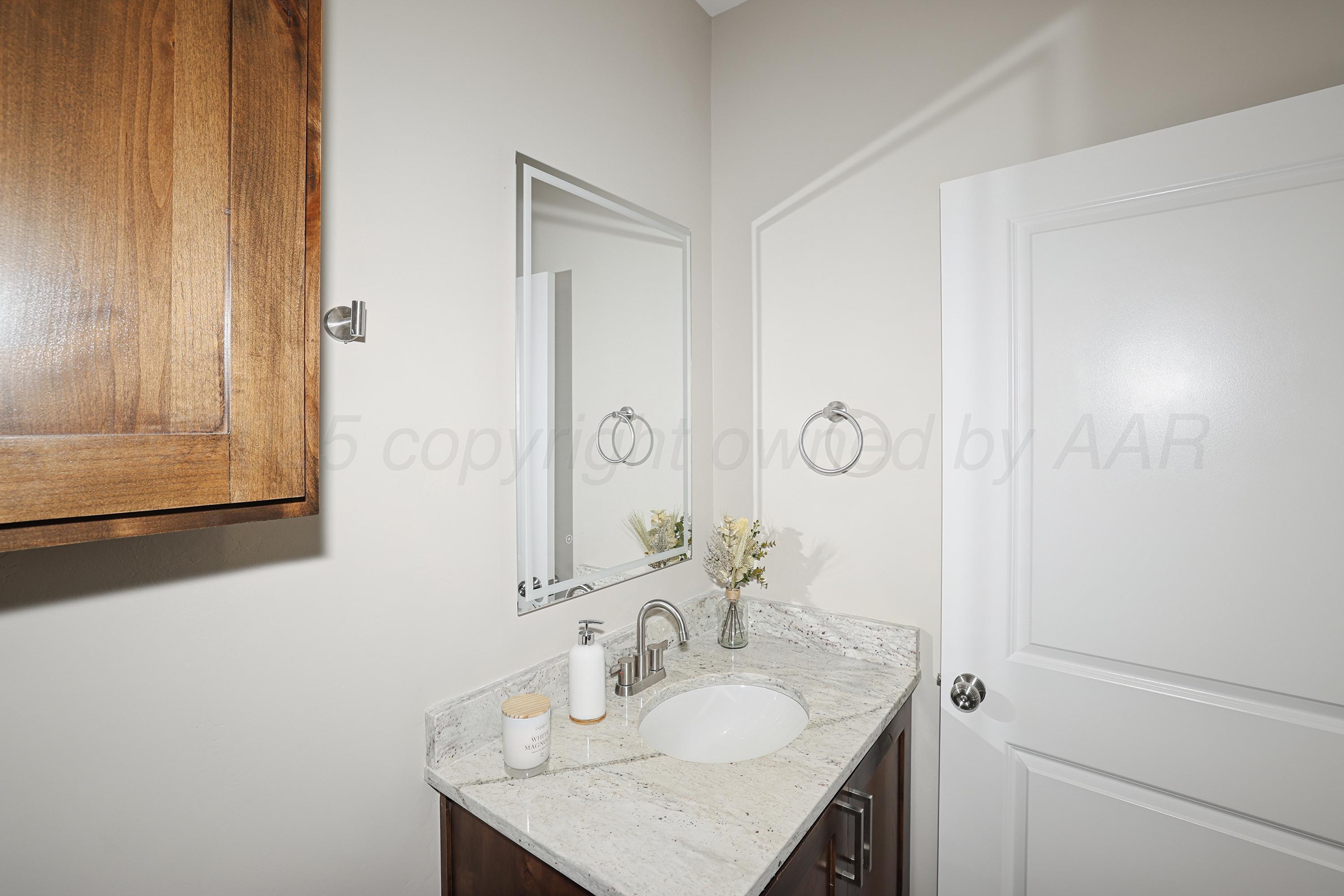 10250 Piper Lane Amarillo, TX 79119 - Photo 17 of 21 a bathroom with a granite countertop sink a mirror and shower