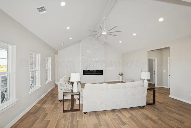 a living room with furniture and a wooden floor