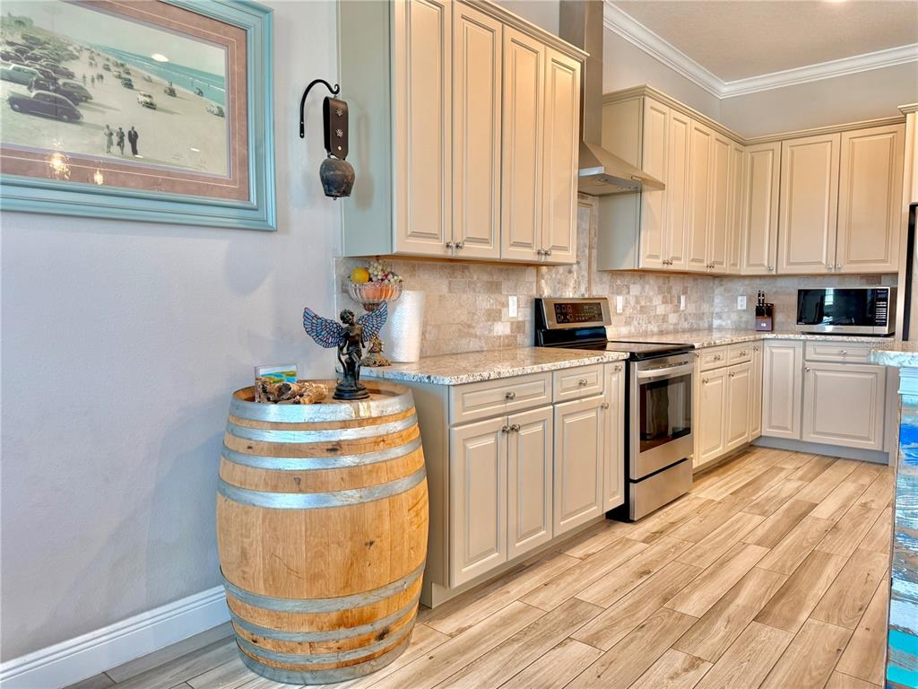 2569 Palm Avenue Flagler Beach, FL 32136 - Photo 12 of 69 a kitchen with stainless steel appliances granite countertop a sink dishwasher a stove and white cabinets with wooden floor