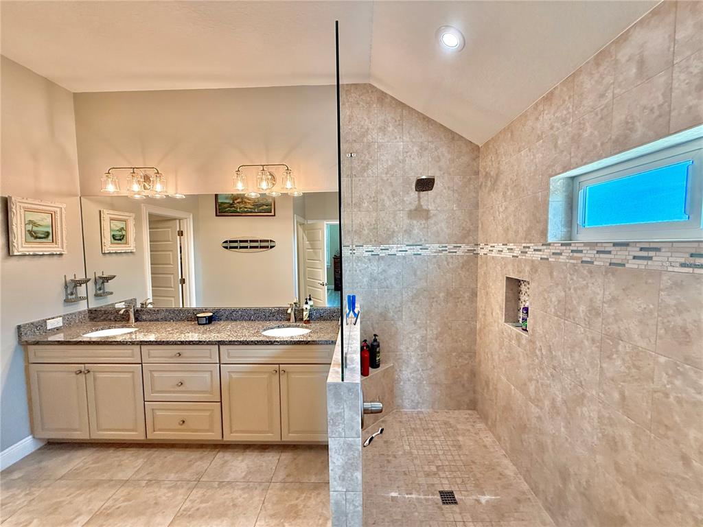 2569 Palm Avenue Flagler Beach, FL 32136 - Photo 30 of 69 a bathroom with a double vanity sink a mirror and a shower