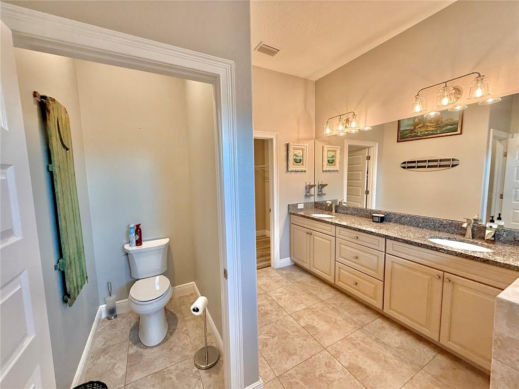 2569 Palm Avenue Flagler Beach, FL 32136 - Photo 36 of 69 a large bathroom with a granite countertop sink a toilet a mirror and shower