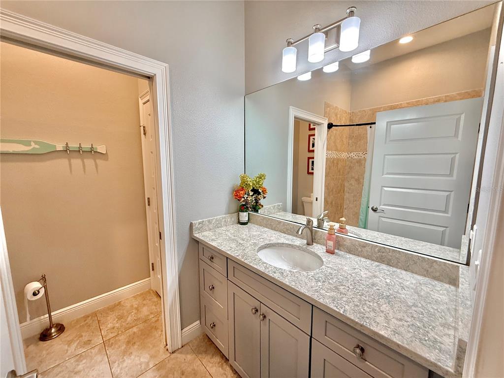 2569 Palm Avenue Flagler Beach, FL 32136 - Photo 50 of 69 a bathroom with a granite countertop sink a mirror and a shower