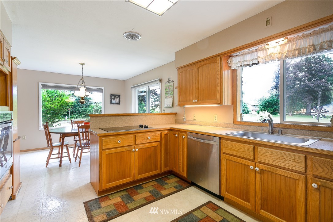 495 West Badger Road Lynden, WA 98264 - Photo 8 of 28 a kitchen with sink cabinets and dining table