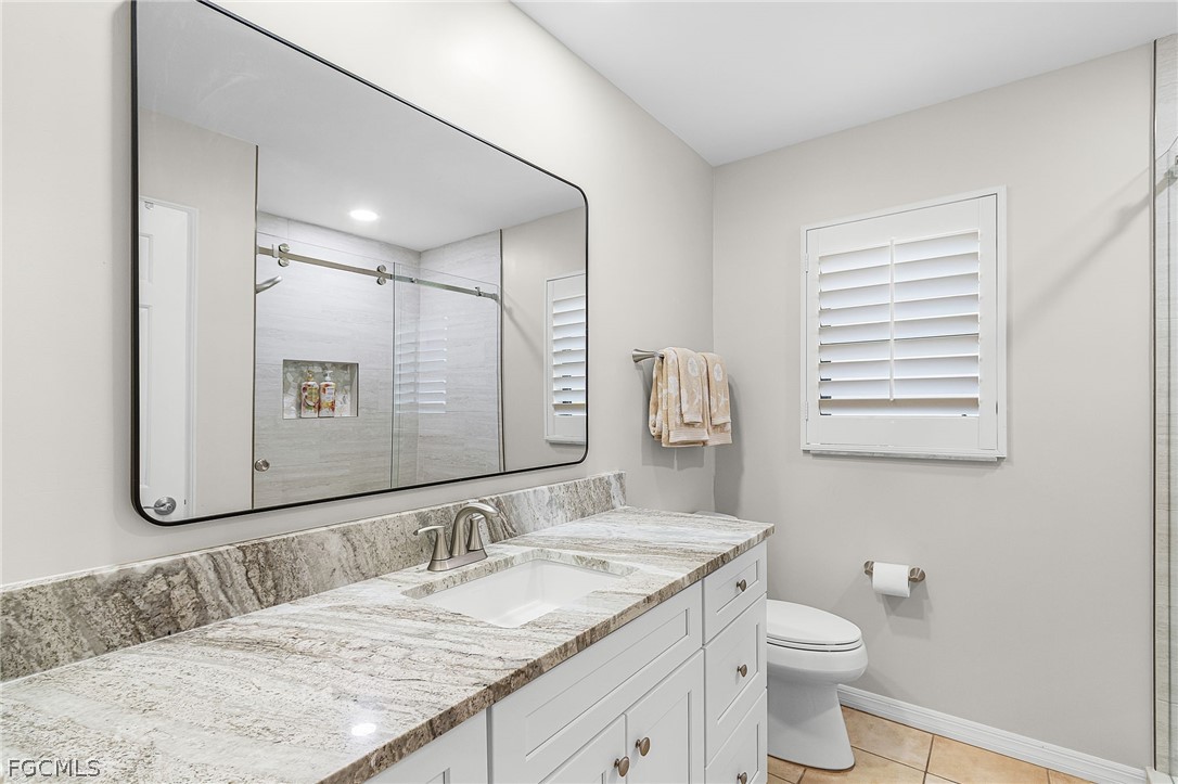 7747 Grande Pine Road Bokeelia, FL 33922 - Photo 26 of 45 a bathroom with a granite countertop sink and a mirror