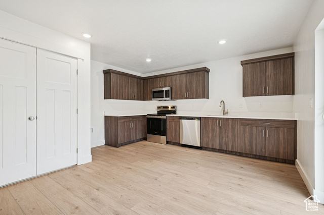 1615 North Angel Street, Unit H Layton, UT 84041 - Photo 19 of 55 Kitchen featuring dark brown cabinetry, light countertops, stainless steel appliances, light wood-style floors, and recessed lighting
