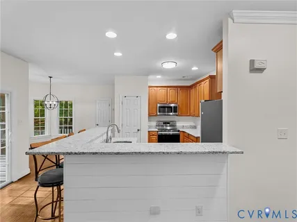 a kitchen with stainless steel appliances granite countertop a refrigerator and a stove top oven