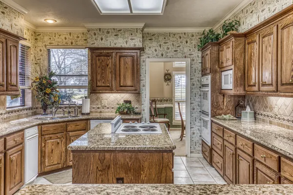a bathroom with a granite countertop sink a mirror and shower