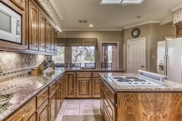 a kitchen with kitchen island granite countertop a stove and a sink