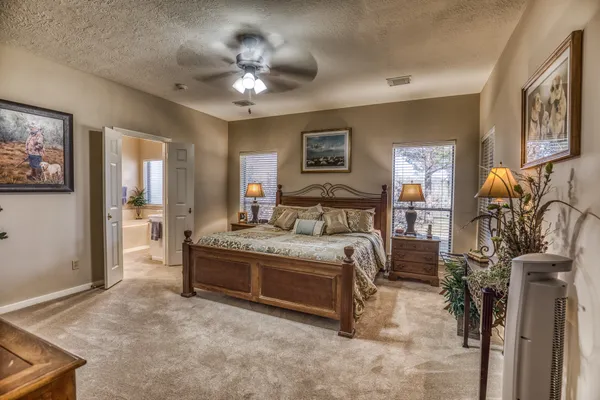 a spacious bedroom with a bed and ceiling fan
