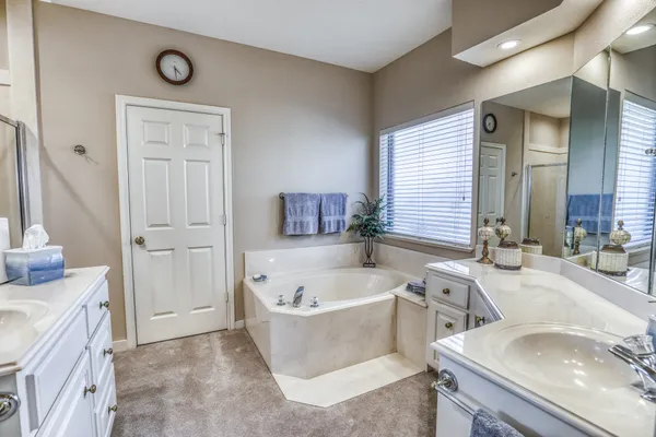 a bathroom with a tub sink and mirror