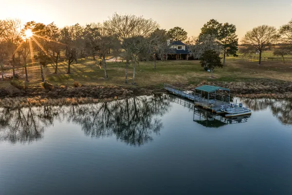 a view of a lake with trees by side of house