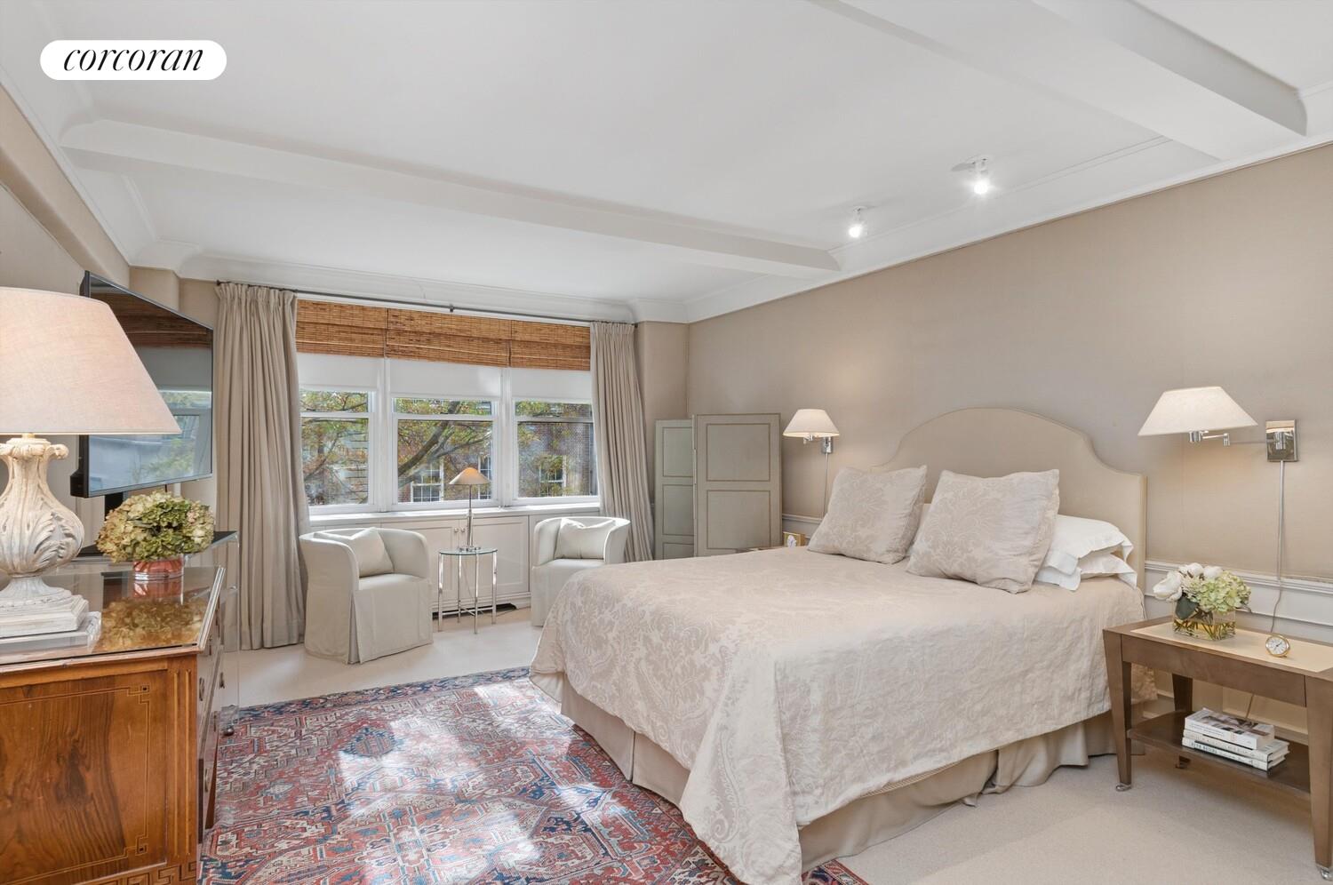 3 East 69th Street, Unit 3/4B Manhattan, NY 10021 - Photo 4 of 8 a bedroom with a large bed and a lamp on table