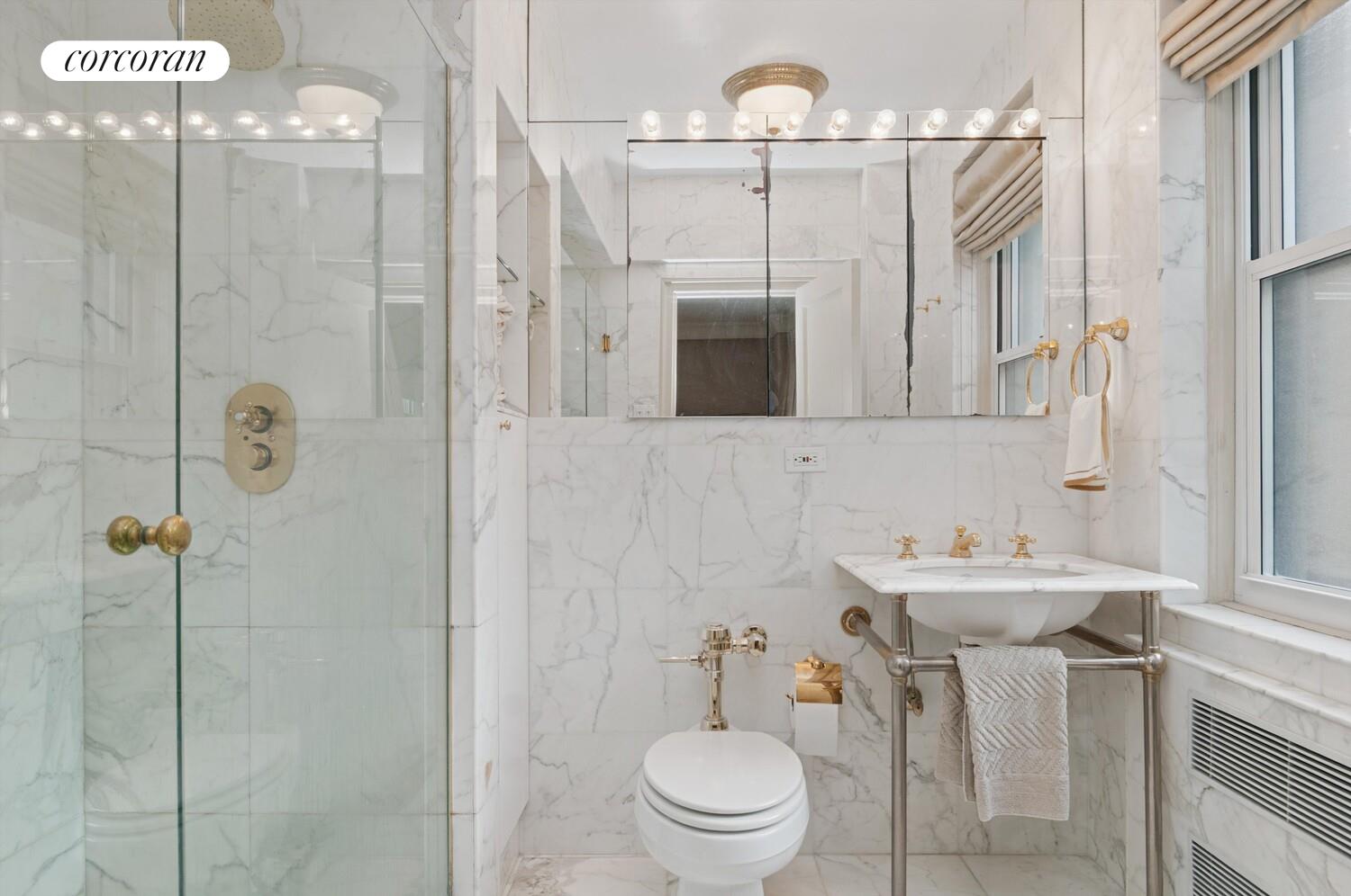 3 East 69th Street, Unit 3/4B Manhattan, NY 10021 - Photo 5 of 8 a bathroom with a sink a toilet a mirror and shower