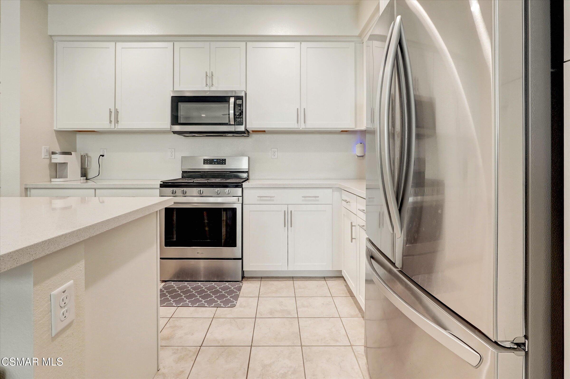310 Farmhouse Drive, Unit 4 Simi Valley, CA 93065 - Photo 10 of 29 a kitchen with a refrigerator sink and cabinets