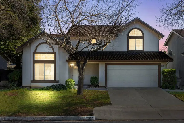 a front view of a house with a yard garage and outdoor seating