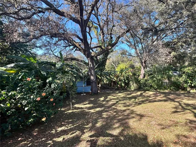 a bed sitting in a bedroom next to a window and a chandelier