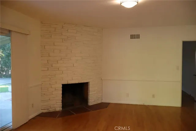 a kitchen with stainless steel appliances granite countertop a refrigerator a sink dishwasher and wooden cabinets with wooden floor