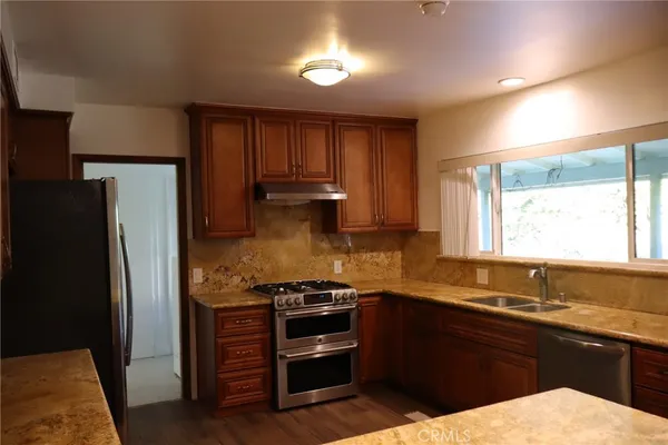 a kitchen with a refrigerator sink and cabinets