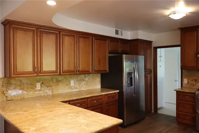 a kitchen with wooden cabinets and stainless steel appliances