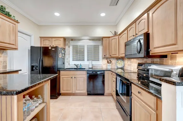 a spacious bedroom with a large bed and a chandelier fan