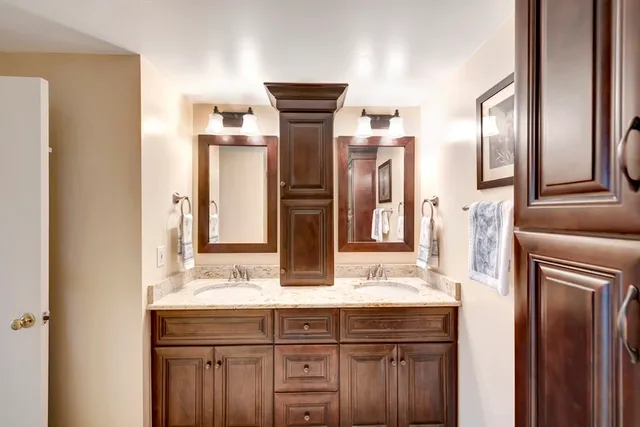 a bathroom with a double vanity sink mirror and chandelier