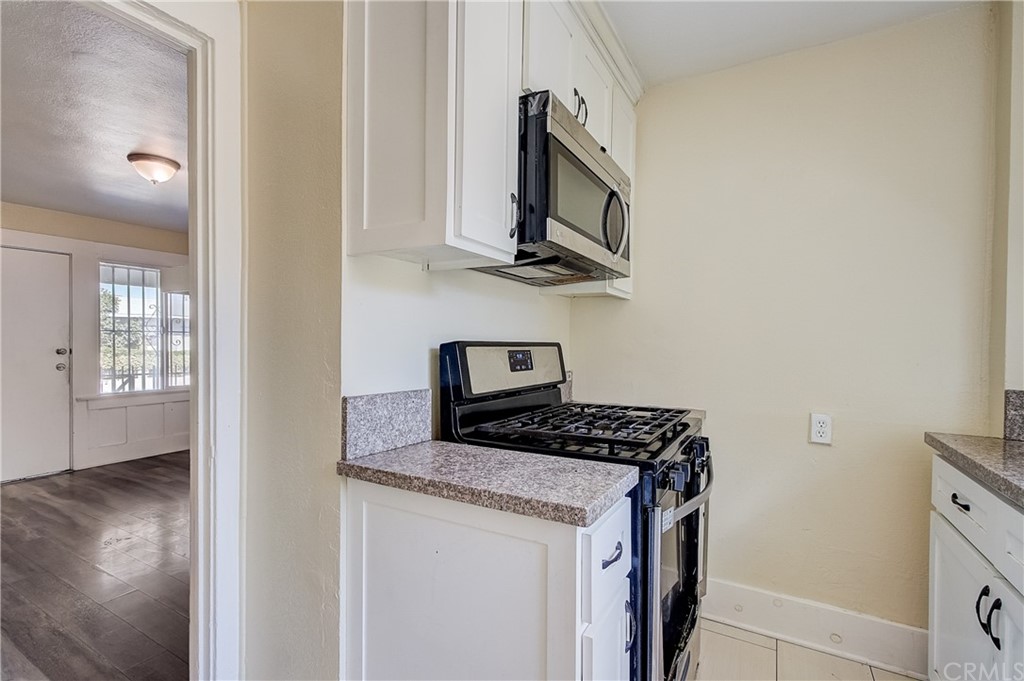 4708 San Pedro Street Los Angeles, CA 90011 - Photo 10 of 19 a kitchen with stainless steel appliances granite countertop a stove a sink and a microwave