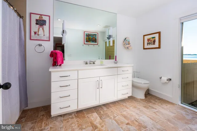 a large white room with a large window and a wooden floor