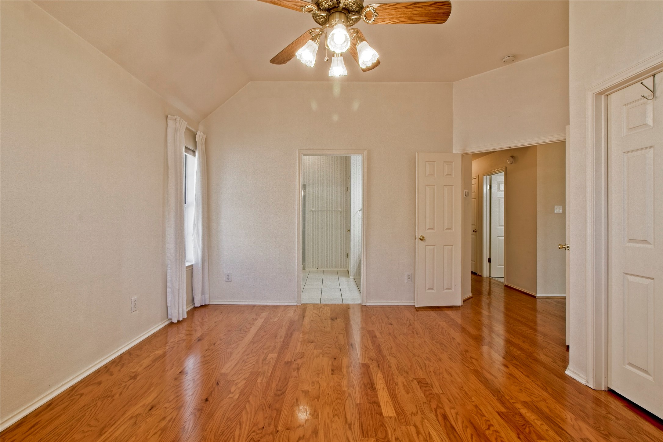108 Rio Vista Drive Georgetown, TX 78626 - Photo 17 of 36 Unfurnished bedroom featuring light wood-style flooring, a ceiling fan, vaulted ceiling, and ensuite bathroom