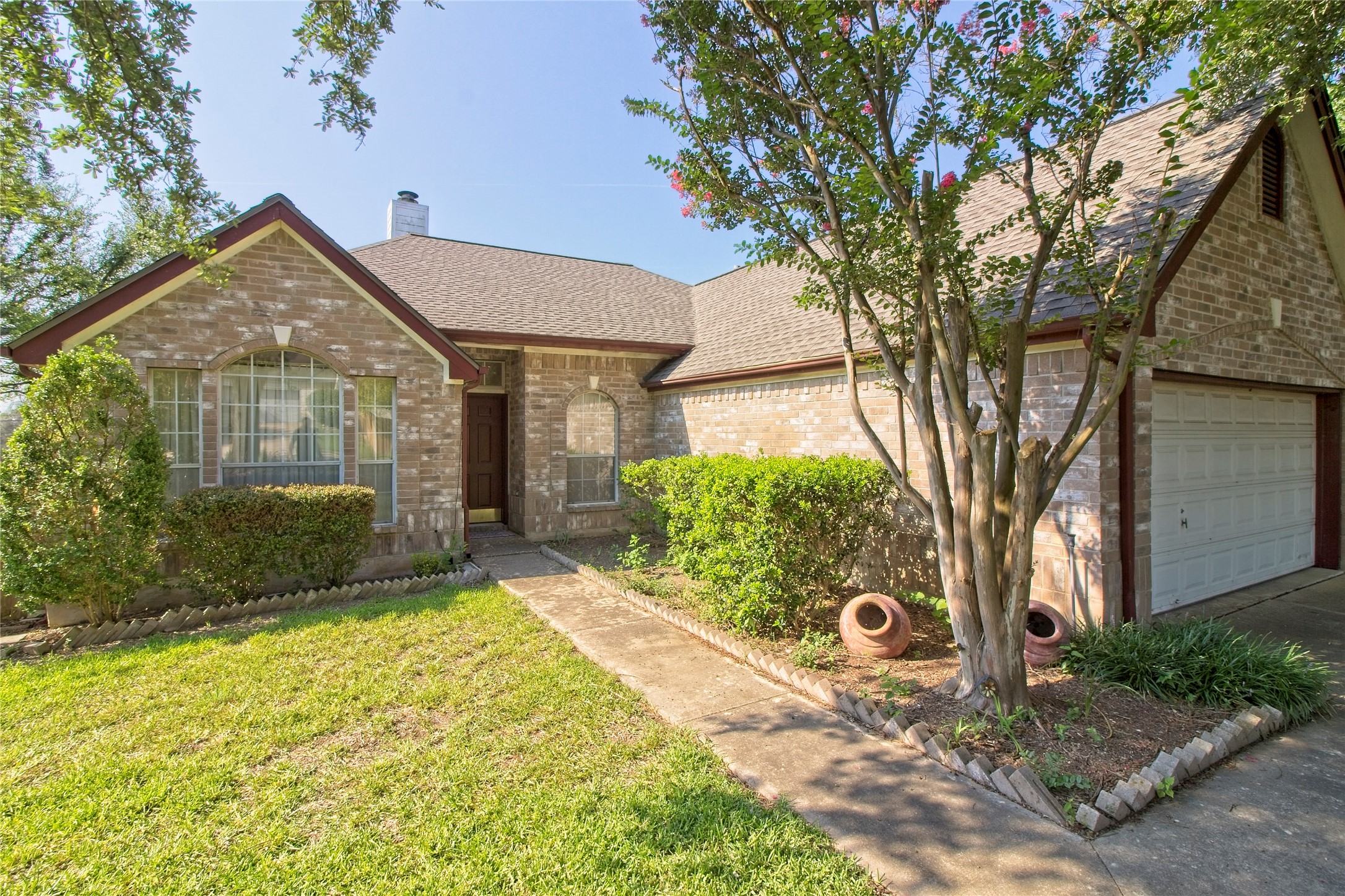 108 Rio Vista Drive Georgetown, TX 78626 - Photo 2 of 36 View of front facade with roof with shingles, brick siding, a front yard, a chimney, and a garage