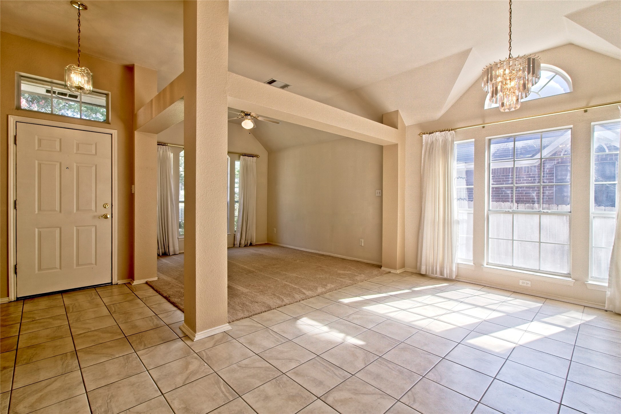 108 Rio Vista Drive Georgetown, TX 78626 - Photo 5 of 36 Entryway featuring a chandelier, a ceiling fan, lofted ceiling, light tile patterned floors, and light carpet