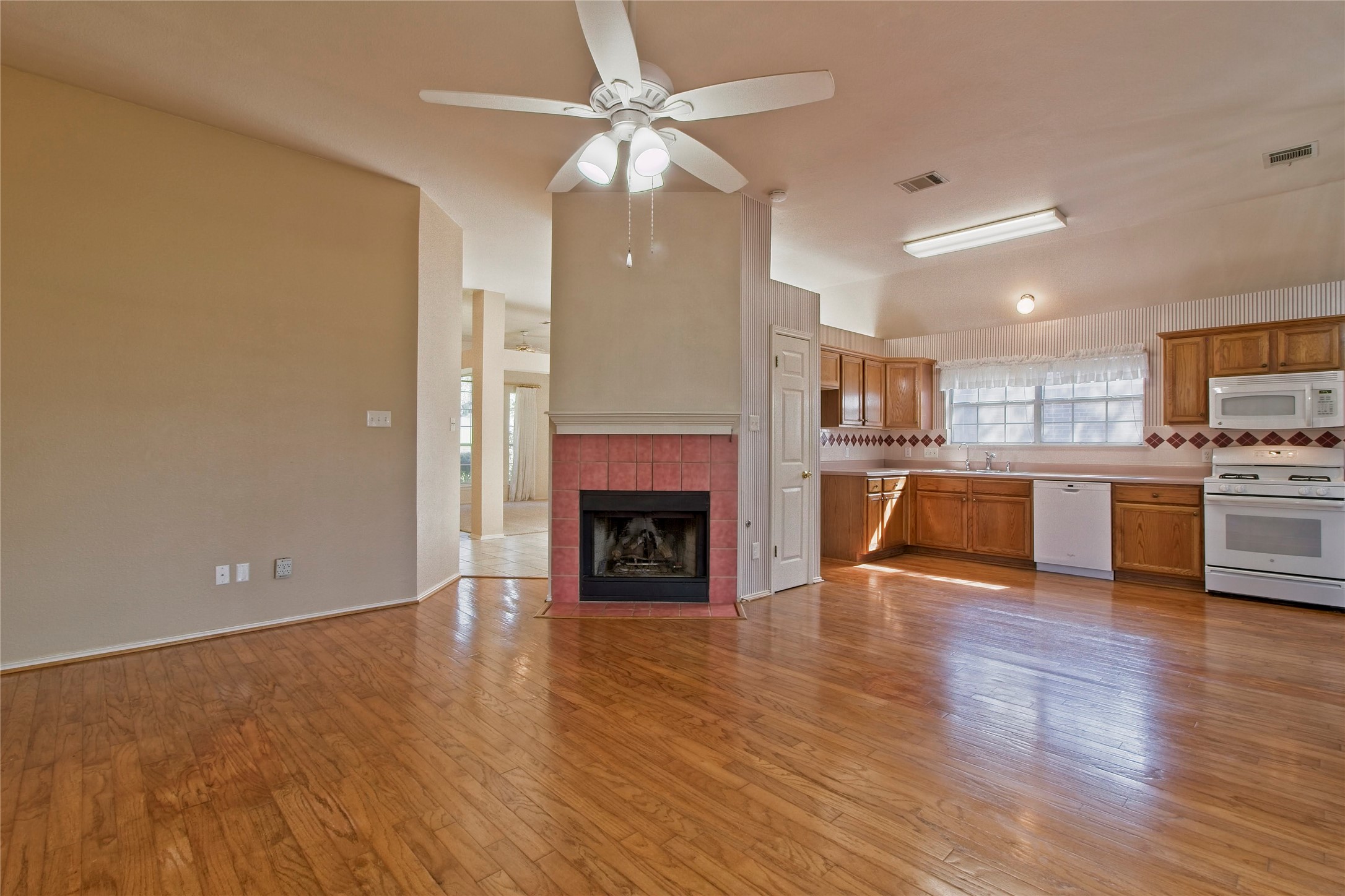 108 Rio Vista Drive Georgetown, TX 78626 - Photo 36 of 36 Kitchen with white appliances, open floor plan, ceiling fan, light countertops, and a tile fireplace
