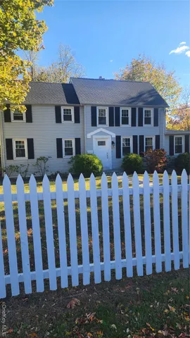 a front view of white house with a garden