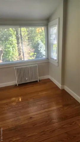 a view of a room with wooden floor and a window