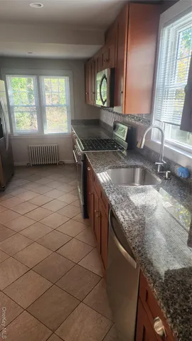 a kitchen with stainless steel appliances granite countertop a sink and a granite counter tops with a window