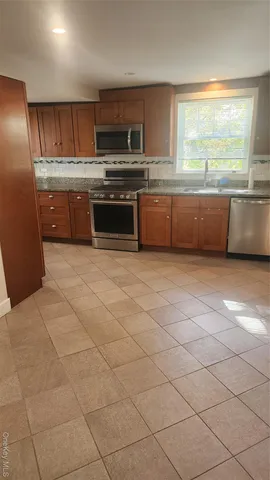 a kitchen with stainless steel appliances granite countertop a stove a sink and a microwave