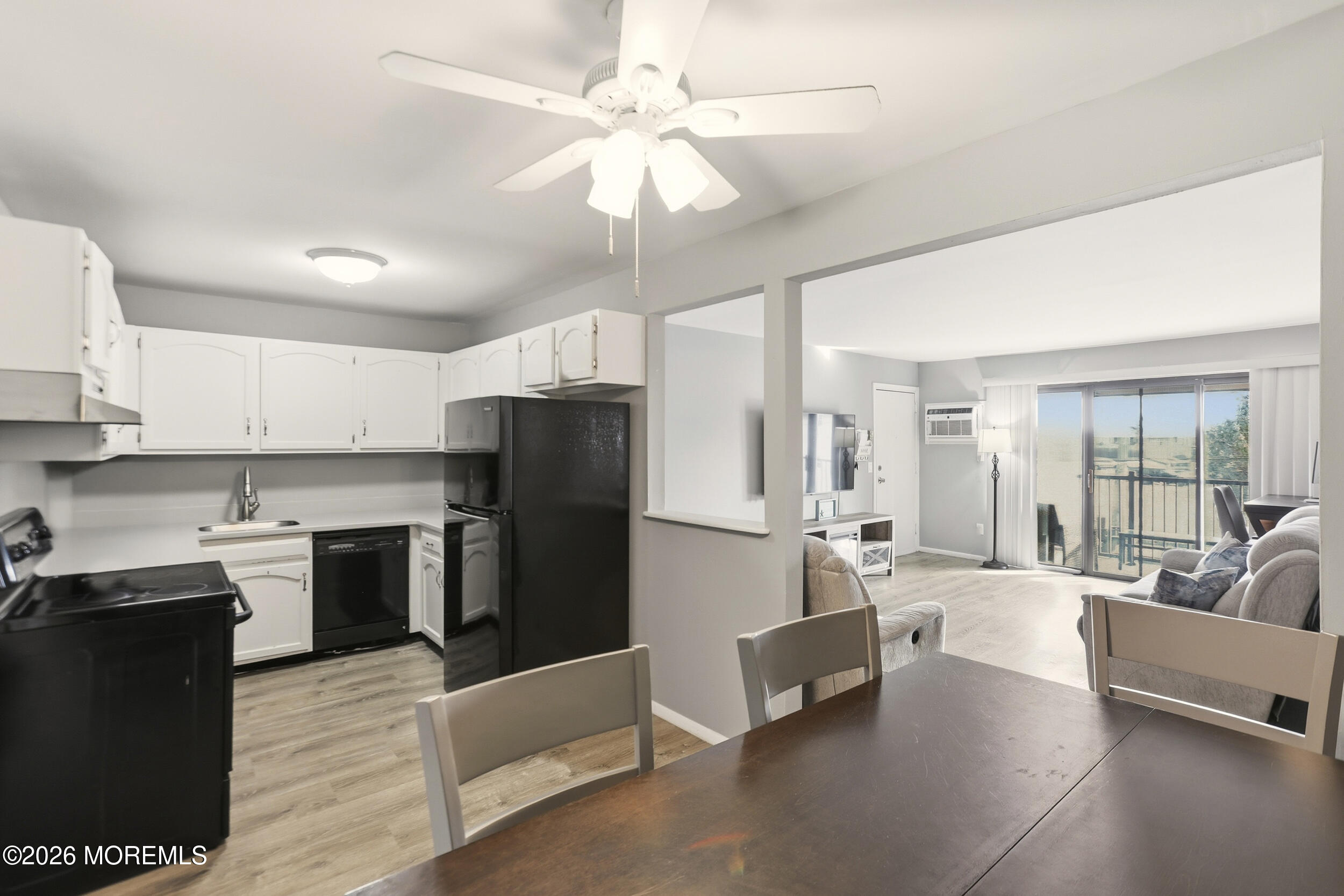 330 Shore Drive, Unit B7 Highlands, NJ 07732 - Photo 12 of 22 a large open kitchen with a refrigerator a stove top oven a sink dishwasher and white cabinets with wooden floor