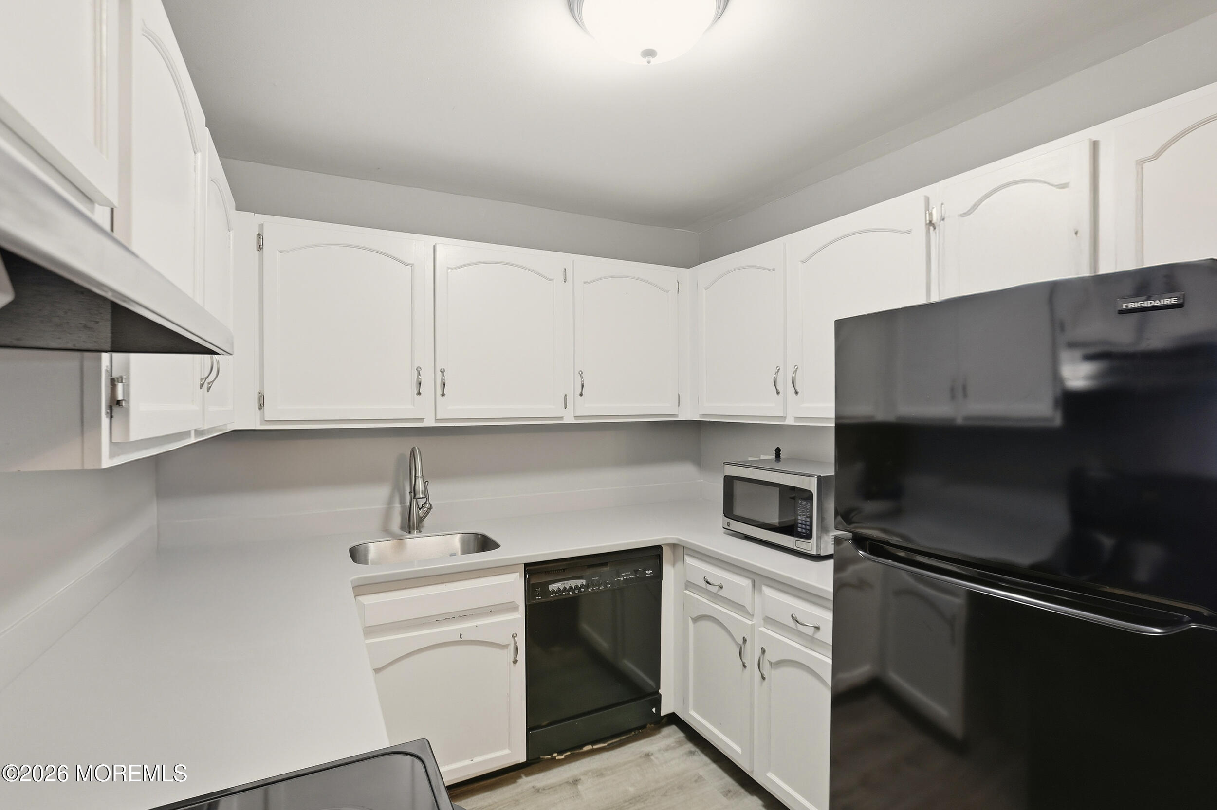 330 Shore Drive, Unit B7 Highlands, NJ 07732 - Photo 14 of 22 a kitchen with white cabinets and stainless steel appliances