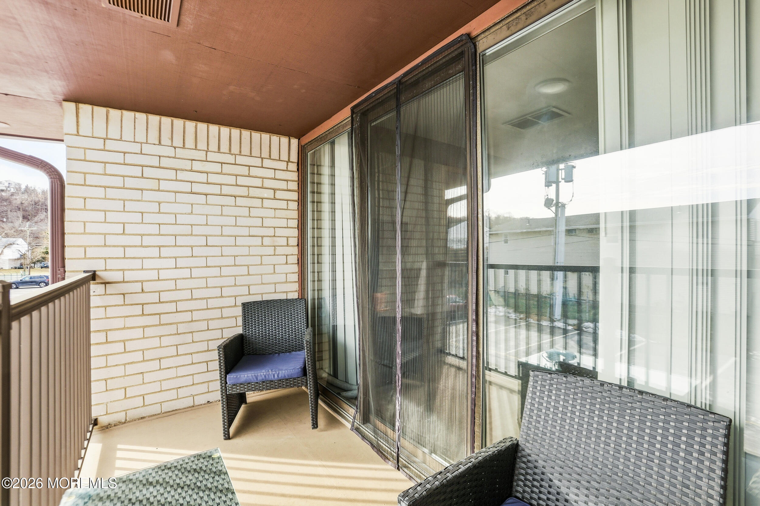 330 Shore Drive, Unit B7 Highlands, NJ 07732 - Photo 5 of 22 a balcony with wooden floor and glass door