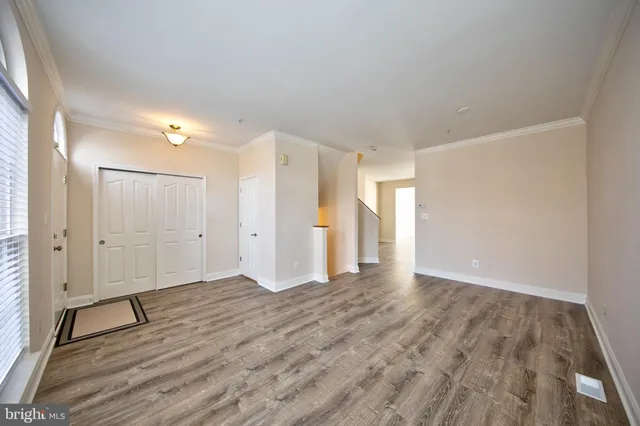 a view of an empty room with wooden floor