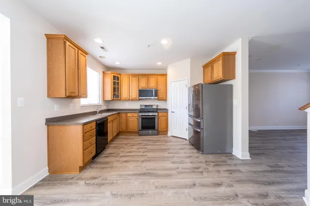 a kitchen with a refrigerator sink and cabinets