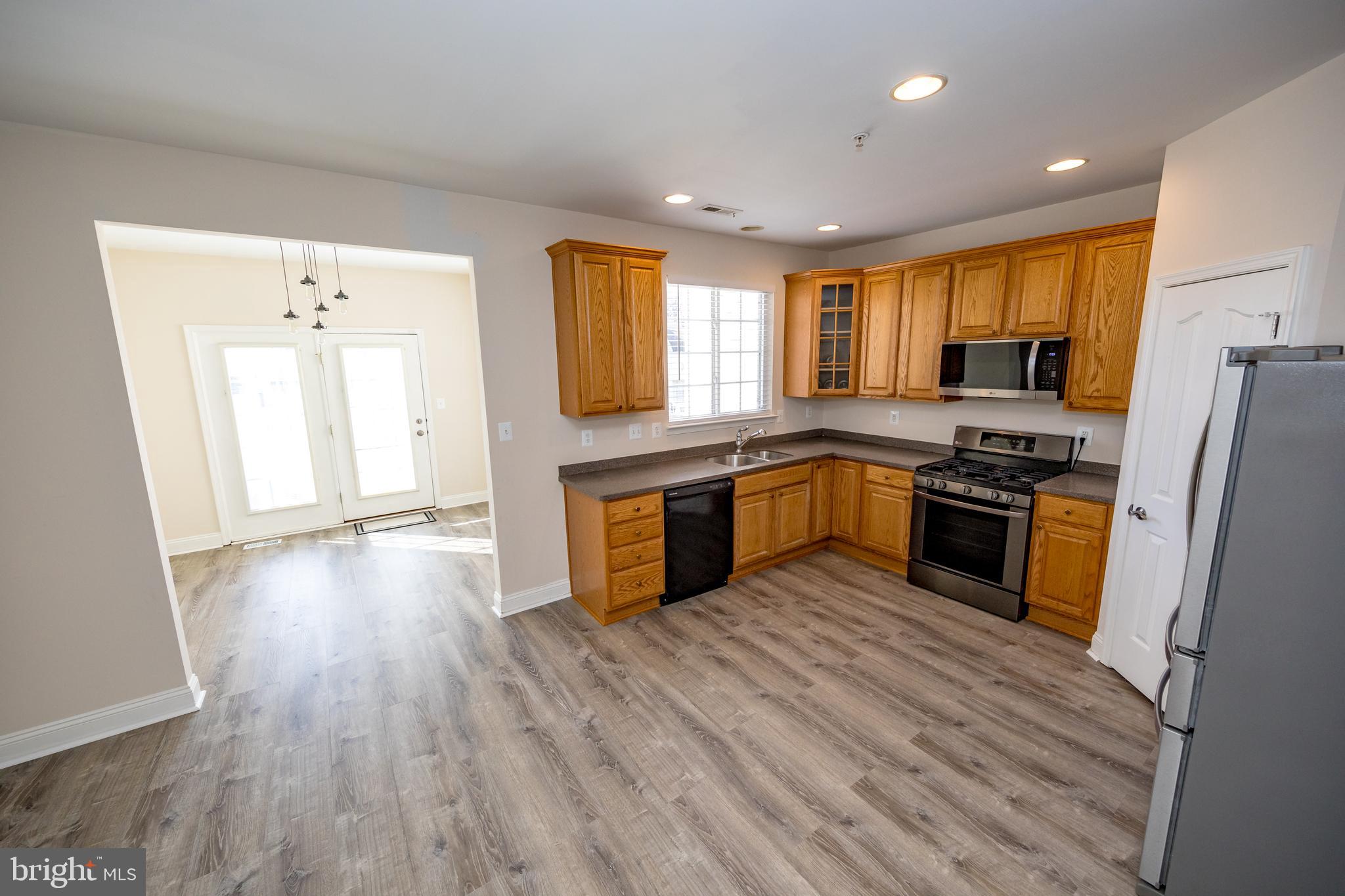 580 Callander Way Abingdon, MD 21009 - Photo 6 of 31 a kitchen with granite countertop wooden floors a stove and a refrigerator