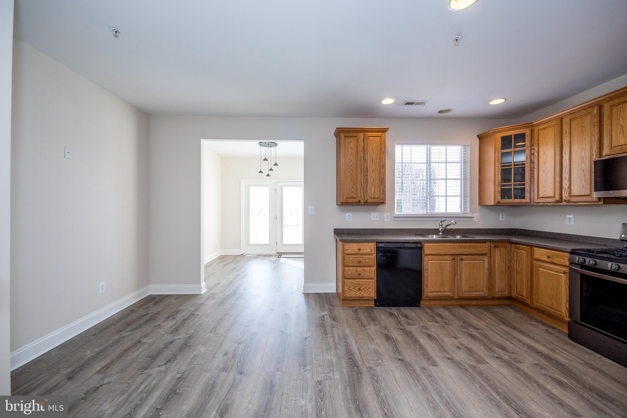 580 Callander Way Abingdon, MD 21009 - Photo 7 of 31 a kitchen with granite countertop a stove top oven a sink dishwasher and a refrigerator with wooden floor